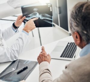 Consultation with traumatologist in Andalucía explaining knee X-ray results to senior patient